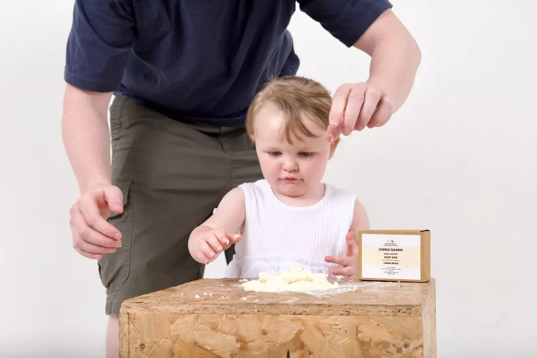 A parent and toddler sharing a playful sensory activity beside an Our Tiny Blends product.